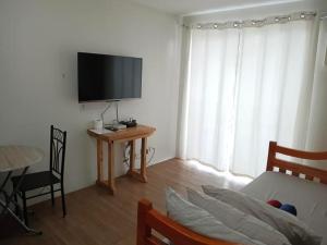 a living room with a tv and a table and a couch at 1BR Condo at The Loop in Pontud