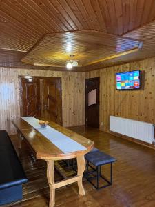 une table en bois dans une pièce avec une télévision dans l'établissement Затишок Карпат, à Vygoda