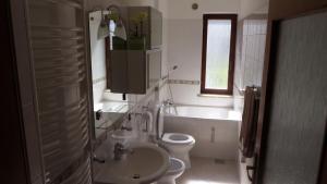 a bathroom with a sink and a toilet and a bath tub at Hisa Lescer in Kobarid +15 photos