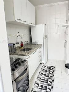 サン・ジョゼ・ドス・カンポスにあるApartamento em frente Shopping Colinasのシンクとコンロのある白いキッチン