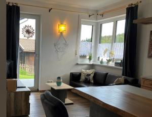 a living room with a couch and a table at Ferien im Kühbergstadl in Bischofsmais