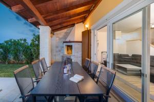 a wooden table and chairs on a patio at Villa Katharina in Krmenjak