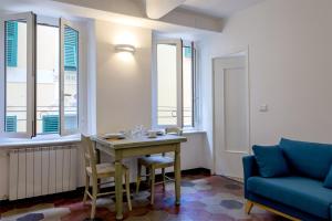 a living room with a table and a blue couch at Il Campanile by Wonderful Italy in Cotulo
