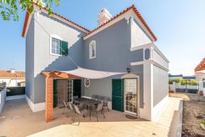 a house with a patio with a table and chairs at GuestReady - Fantastic family home in Sesimbra in Sesimbra