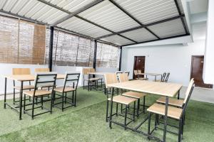 un groupe de tables et de chaises dans une pièce avec de l'herbe dans l'établissement Super Townhouse De Alphabet Kukatpally Near Nexus Mall, à Hyderabad