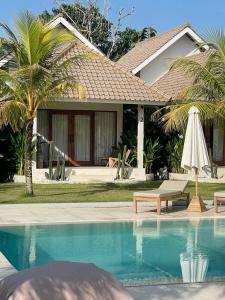 a house with a swimming pool and a umbrella at Nakama in Badung +27 photos