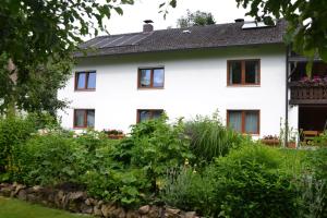 a white house with a garden in front of it at Ferienwohnung Seebauer in Ramspau