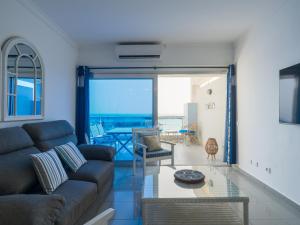 a living room with a couch and a view of the ocean at Blue Horizon Mogan in Puerto de Mogán