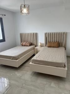 Un dormitorio con dos camas en una habitación. en 2BR Haut Standing Avec Piscine Face Hôtel Movenpick Sousse, en Sousse