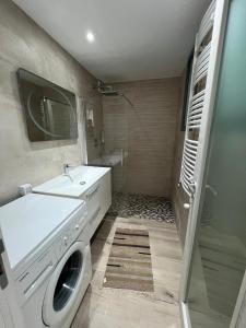 Un baño con lavabo y lavadora. en 2BR Haut Standing Avec Piscine Face Hôtel Movenpick Sousse, en Sousse 7 fotos más