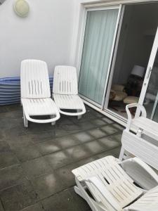 three white chairs sitting on a balcony at 45 st Nicholas Court in St Ives