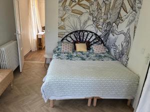 a small bedroom with a bed with a wall at Chez iris in Noisy-le-Grand