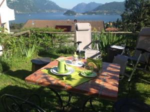 a picnic table in the yard with a view of the water at B&B By Lussy - Camera Verde in Menaggio