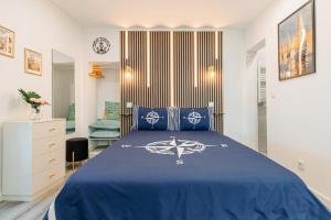 a bedroom with a bed with a blue bedspread at Seixal Yachting Bay Studio in Seixal