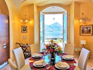 La Villa di Elena في فيربانيا: غرفة طعام مع طاولة ونافذة كبيرة +صورتان