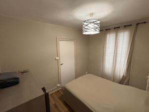 a small bedroom with a bed and a light at T2 Rénové, centre, parking privé in Limoges