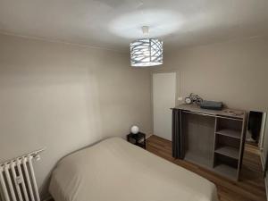 a bedroom with a bed and a desk in it at T2 Rénové, centre, parking privé in Limoges