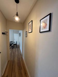 a hallway with two pictures on the wall and a table at T2 Rénové, centre, parking privé in Limoges