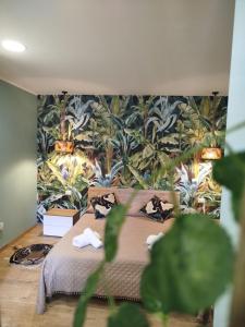 um quarto com uma cama com papel de parede tropical em Avusa Home em Palermo