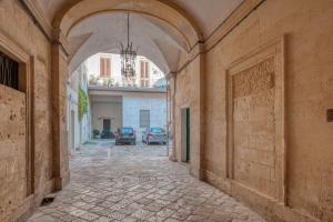 an alley way with an archway in a building at San Leonardo Apartments in Lecce