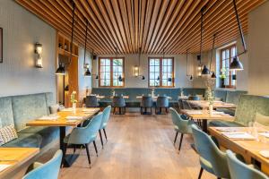 a restaurant with wooden ceilings and tables and chairs at Goldammer Aschaffenburg in Aschaffenburg