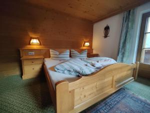 a bedroom with a large wooden bed in a room at Haus Elisabeth in Hainzenberg