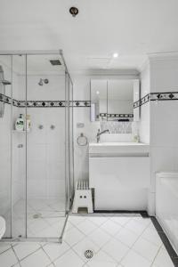 a white bathroom with a shower and a sink at 92AH Abnb-Style Central Sydney 1BR, Free Parking, Prime Location in Sydney