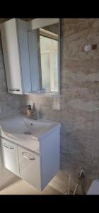 a bathroom with a white sink and a mirror at Ariona apartment in Draç +22 photos