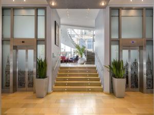 亚琛美居亚琛多姆酒店的摆满盆栽的建筑物楼梯