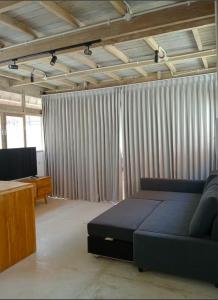 een woonkamer met een blauwe bank en een tafel bij Villa Lumbung Uluwatu 1 in Uluwatu