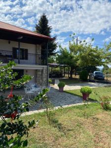 a view of a house with a yard at Cosy lake house, μια ανάσα πριν τη λίμνη in Kalyvia