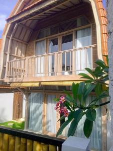 een huis met een balkon en een potplant bij Villa Lumbung Uluwatu 1 in Uluwatu +14 foto's
