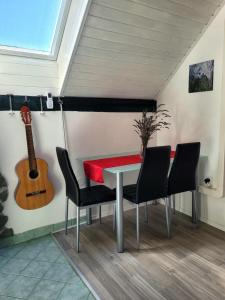 a table and chairs in a room with a guitar at Babičina hišica in Mišji Dol +11 photos