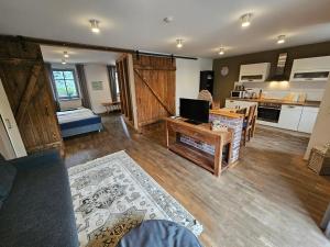 a living room with a television and a kitchen at BluGarden Ferienapartments im Spreewald in Lübben
