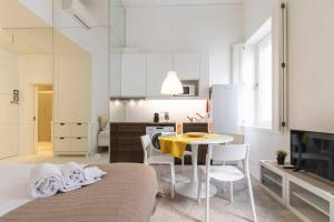 a bedroom with a bed and a table and a kitchen at Charming and Well-Located Studio in Chiado in Lisbon