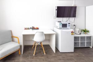 a room with a desk with a microwave and a chair at Proserpine Motel in Proserpine +18 photos