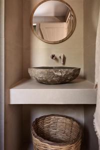 a bathroom with a stone sink and a mirror at Conte Maris VI in Tragaki