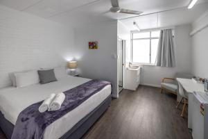 Un dormitorio con una cama con toallas. en Proserpine Motel, en Proserpine 2 fotos más