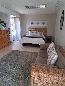 a bedroom with a bed and a couch and a bed at 258 on Aries in Pretoria