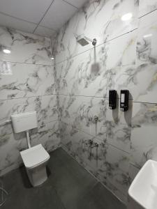 a bathroom with a toilet and a sink at Hotel Ravechi Krupa in Kotharia