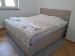 a bed with white sheets and two towels on it at Apartma Dea in Nova Gorica