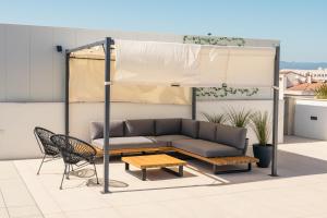 a couch and a table and a chair on a roof at Instants Boutique Hotel in Cambrils