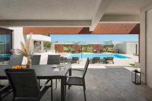 a patio with a table and chairs and a pool at Villa Scallop ZadarVillas in Podlug +44 photos