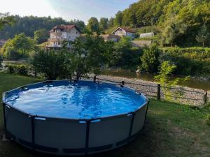 にあるKrivaja River Retreat - Jacuzzi, Pool and Basketballの川のそばの草の上に置かれた大きな桶