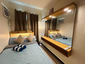 a bedroom with two beds and a large mirror at Cozy 1br with Netflix in Makati CBD in Manila +24 photos