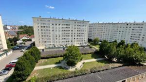 a large white building with trees in front of a street at Le Balcon Bohème - Troyes à pied et Parking in Saint-André-les-Vergers