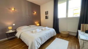 a bedroom with a bed with two towels on it at Le Balcon Bohème - Troyes à pied et Parking in Saint-André-les-Vergers