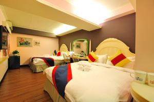 a hotel room with three beds and a room with at Elizabeth Hotel in Taichung