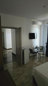 a room with a bed and a table and a television at Damar in Costinesti +5 photos