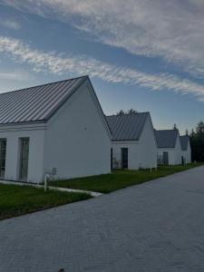 a large white building with a gray roof at Domy w Wycinkach in Wycinki